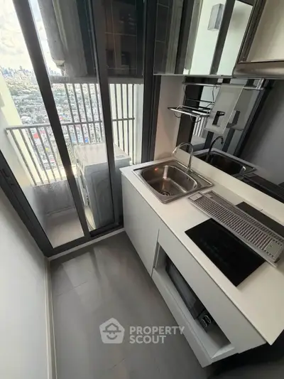 Modern compact kitchen with city view and sleek appliances
