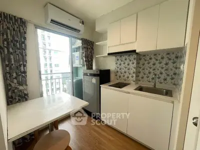 Charming compact kitchen with modern appliances and floral backsplash in cozy apartment.