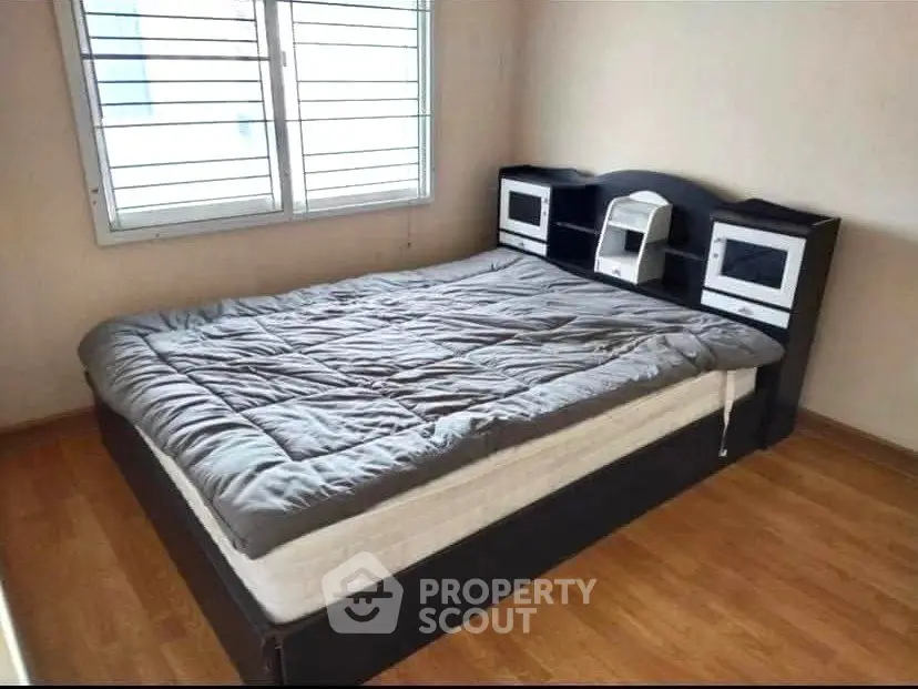 Cozy bedroom with modern bed and wooden flooring, perfect for relaxation.