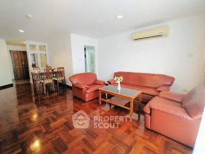 Spacious living room with elegant wooden flooring and comfortable leather seating