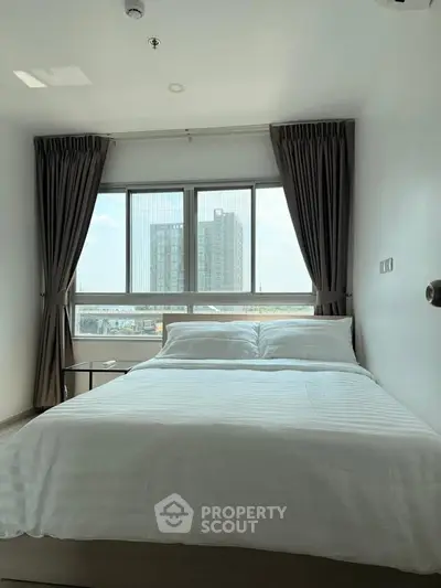Bright bedroom with large window and city view, featuring a comfortable bed and modern decor.