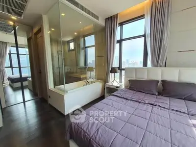 Luxurious bedroom with city view and glass-enclosed bathtub, modern design.