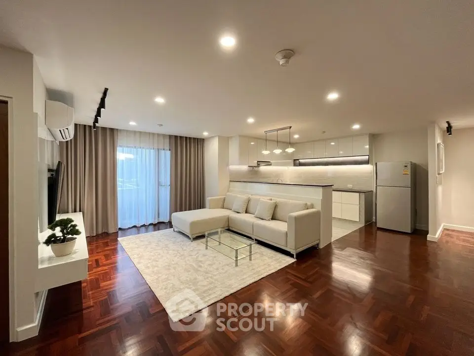 Spacious modern living room with open kitchen and elegant hardwood floors