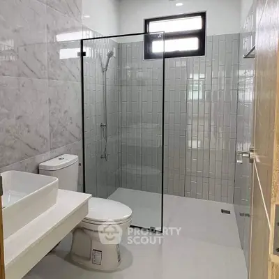 Modern bathroom with glass shower enclosure and sleek fixtures