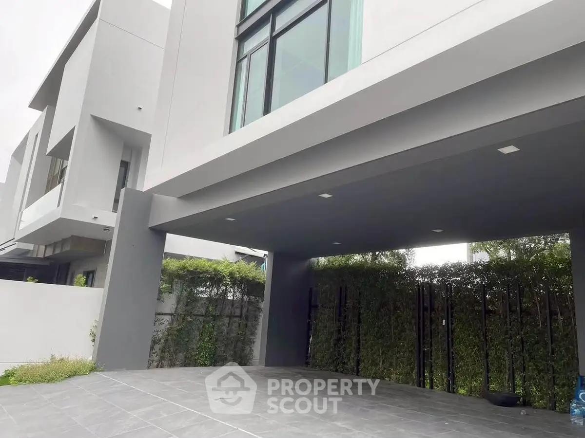 Modern architectural exterior with sleek design and spacious driveway.