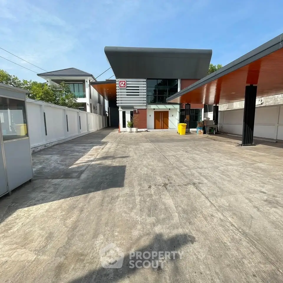 Modern commercial building with spacious parking area and sleek architectural design.