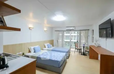 Modern bedroom with twin beds, balcony view, and stylish decor in a spacious apartment.