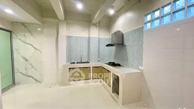 Modern kitchen with sleek cabinetry and tiled backsplash in a spacious layout.