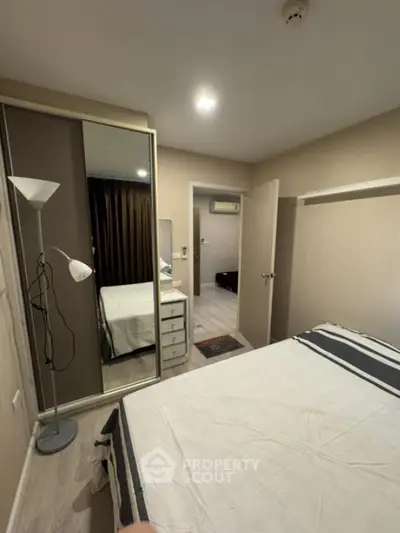 Cozy bedroom with mirrored wardrobe and modern decor in a stylish apartment