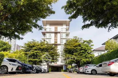 Modern apartment building with lush greenery and ample parking space
