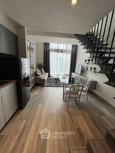 Modern living room with high ceiling and stylish staircase in a contemporary apartment.