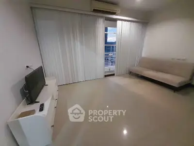 Spacious living room with balcony access and modern furnishings