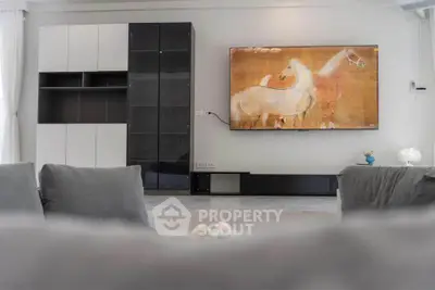 Modern living room with sleek black and white cabinetry and wall-mounted TV