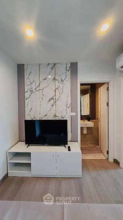Modern living room with stylish marble accent wall and sleek TV setup