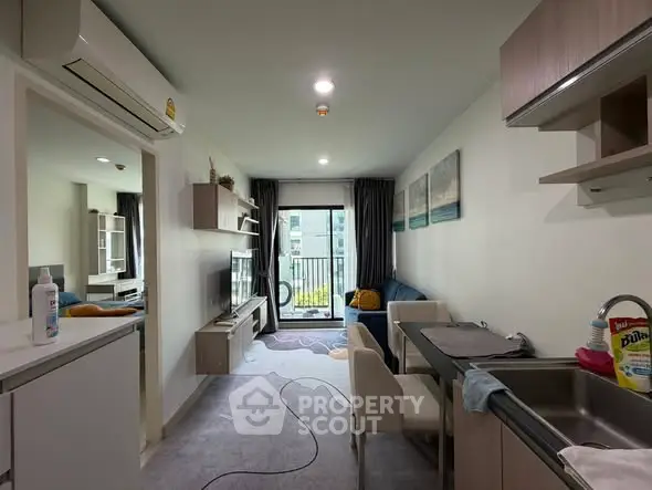 Modern living room with open kitchen and balcony view in stylish apartment