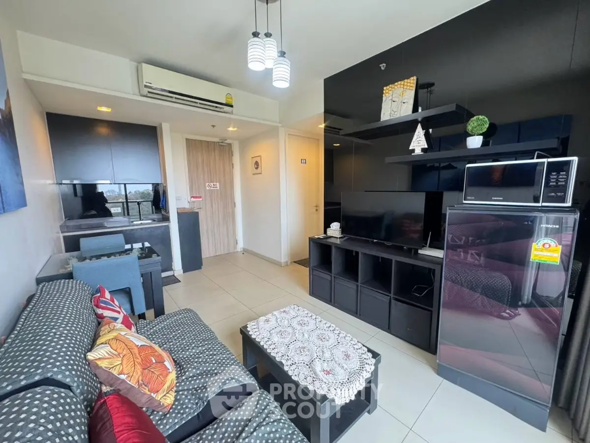 Modern living room with stylish decor and open layout, featuring a cozy sofa and entertainment center.