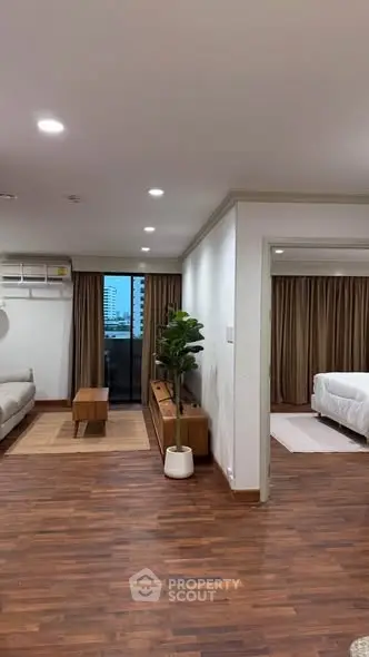 Spacious open-plan living room with hardwood floors and modern decor