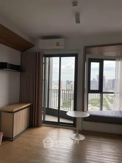 Modern apartment with balcony and city view, featuring sleek interior design and natural light.