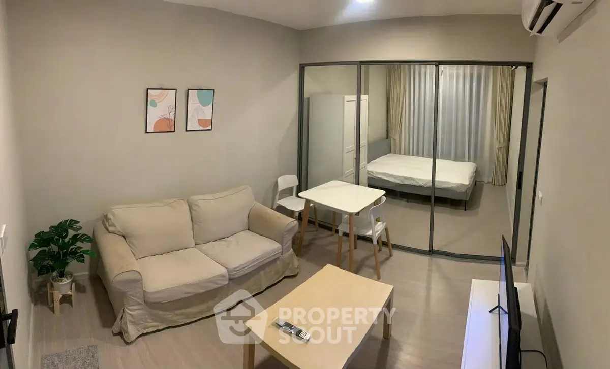 Modern studio apartment with glass partition, cozy living area, and minimalist decor.