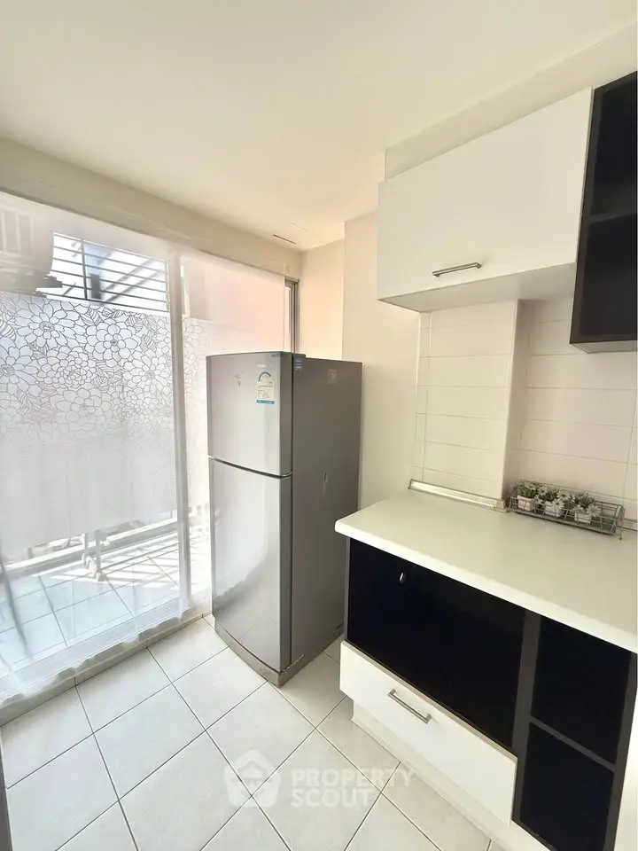 Modern kitchen with sleek fridge and ample natural light