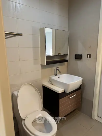 Modern bathroom with sleek sink and toilet in contemporary apartment.