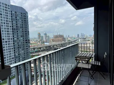 Stunning city view from a modern high-rise balcony with cozy seating.