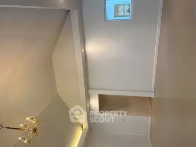 Spacious interior with high ceilings and elegant chandelier, perfect for modern living.