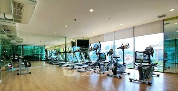 Spacious modern gym with city view and state-of-the-art equipment.