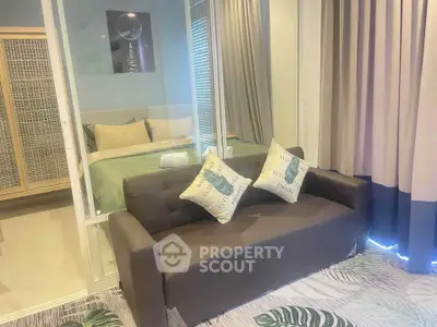 Modern bedroom with glass partition and cozy sofa, perfect for stylish urban living.