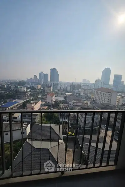 Stunning cityscape view from a high-rise balcony showcasing urban skyline and clear skies.