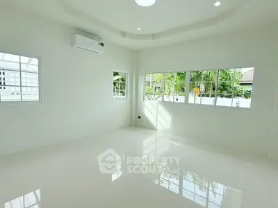 Spacious and bright living room with large windows and air conditioning