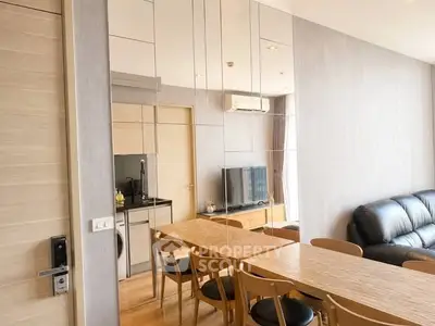 Modern living room with mirrored wall, sleek dining table, and cozy seating area.