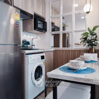 Modern kitchen with washing machine and dining area in stylish apartment