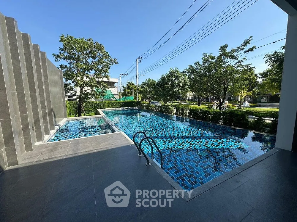 Luxurious outdoor pool with modern design and lush greenery, perfect for relaxation and leisure.