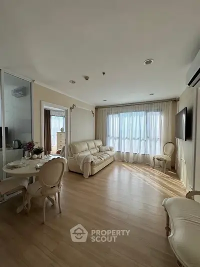 Elegant living room with natural light, cozy seating, and stylish decor