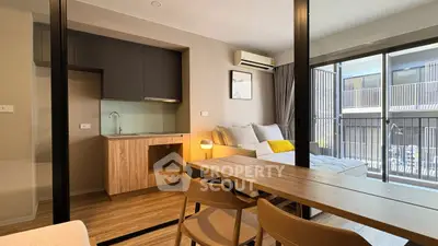 Modern studio apartment with open layout, featuring a cozy living area and compact kitchen.