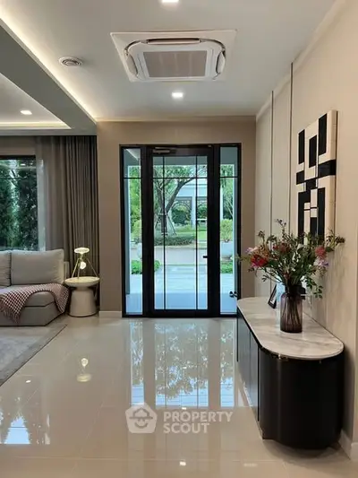 Modern living room with stylish decor and large windows overlooking garden