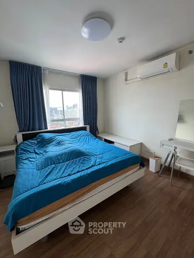 Spacious bedroom with city view, featuring modern furnishings and air conditioning, perfect for urban living.