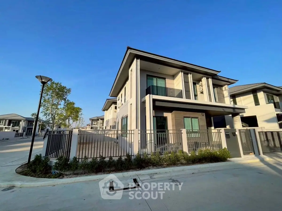 Modern two-story house with sleek design and spacious driveway in a serene neighborhood.