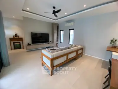 Spacious modern living room with sleek furniture and large TV setup