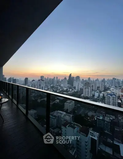 Stunning cityscape view from a high-rise balcony at sunset, showcasing urban skyline.