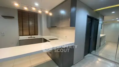 Modern kitchen with sleek design, featuring glossy cabinets and a minimalist breakfast bar.