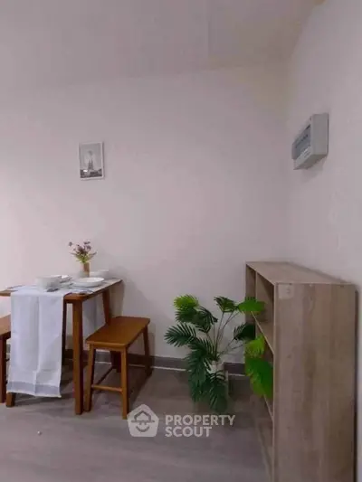 Cozy dining area with wooden furniture and decorative plant, perfect for intimate meals.