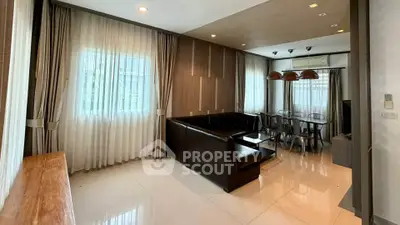 Spacious modern living room with elegant dining area and natural light.