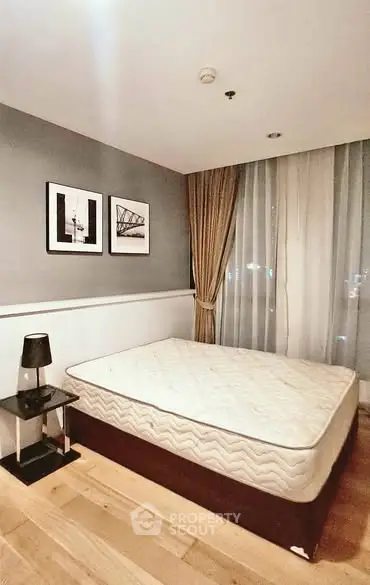 Modern bedroom with stylish decor and large window in a contemporary apartment.