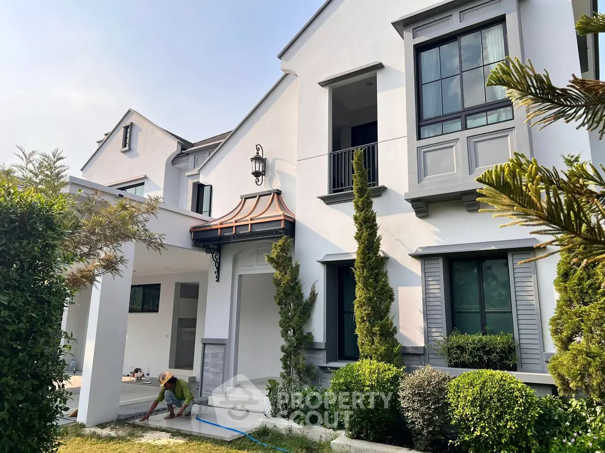 Elegant modern house exterior with lush greenery and stylish architectural details.