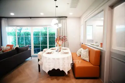 Stylish open-plan living and dining area with modern decor and large windows.