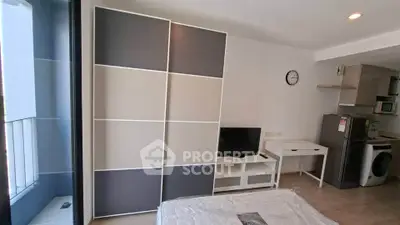 Modern apartment interior with stylish wardrobe, TV, and compact kitchen area.