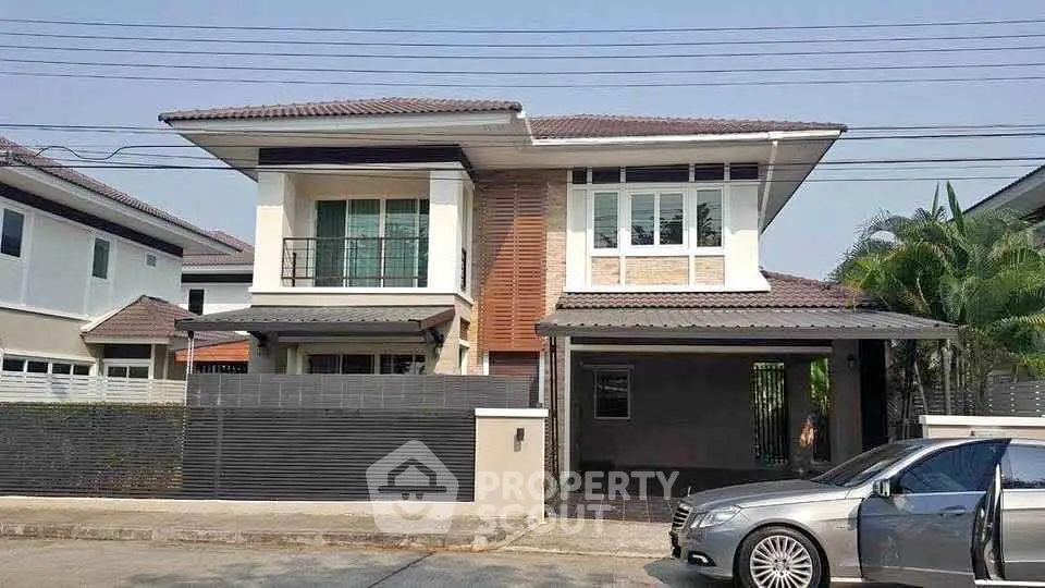 Modern two-story house with sleek design and spacious driveway in a suburban neighborhood.