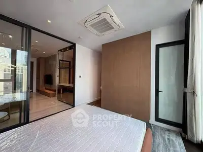 Modern bedroom with large windows and glass partition in a stylish apartment.